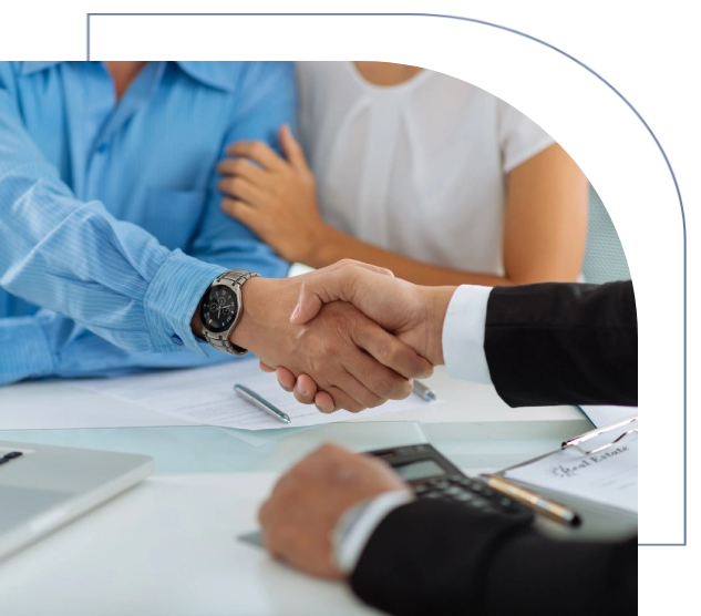 A man and woman shaking hands over a table.