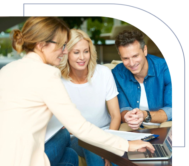 A woman standing next to two men on a laptop.