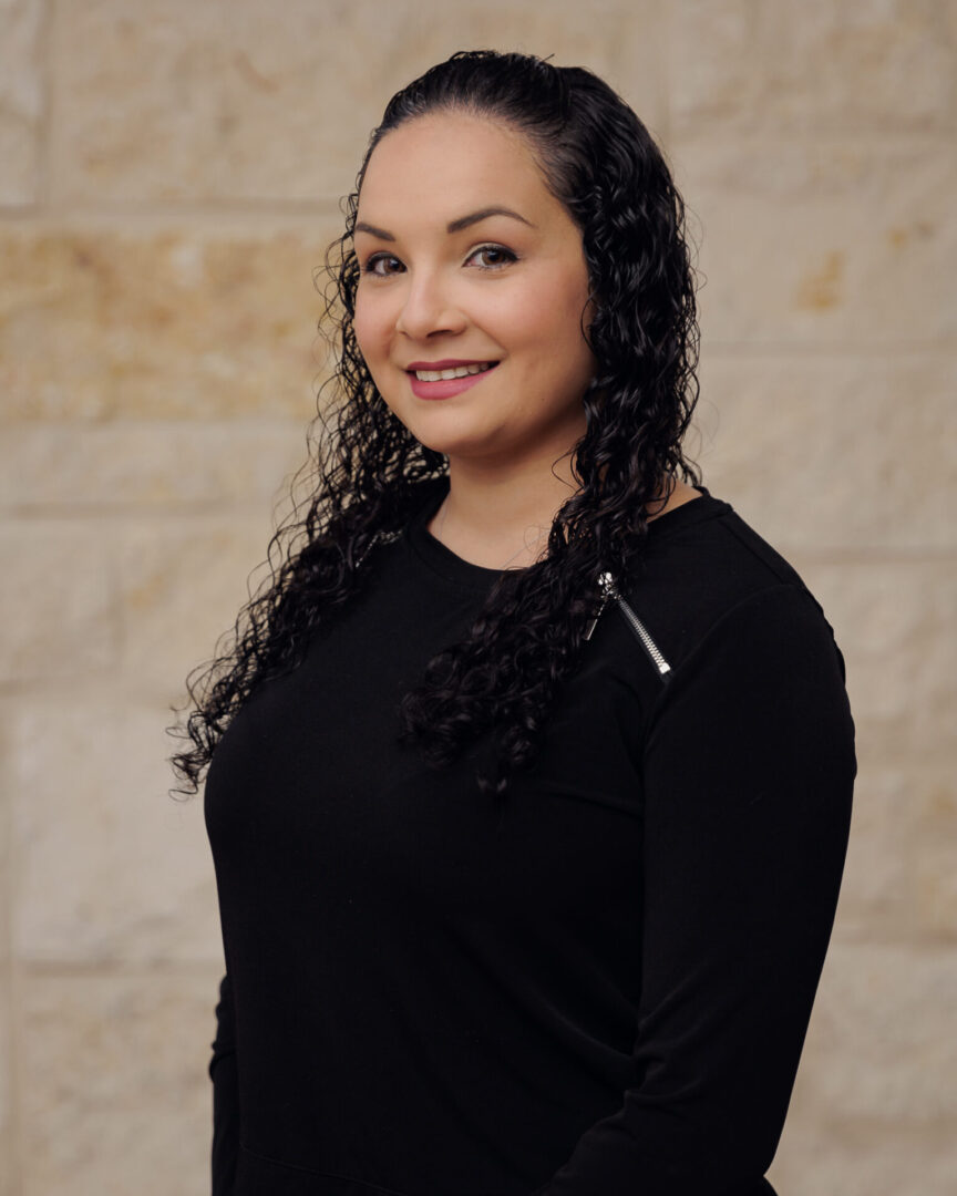 A woman with long black hair wearing a black shirt.